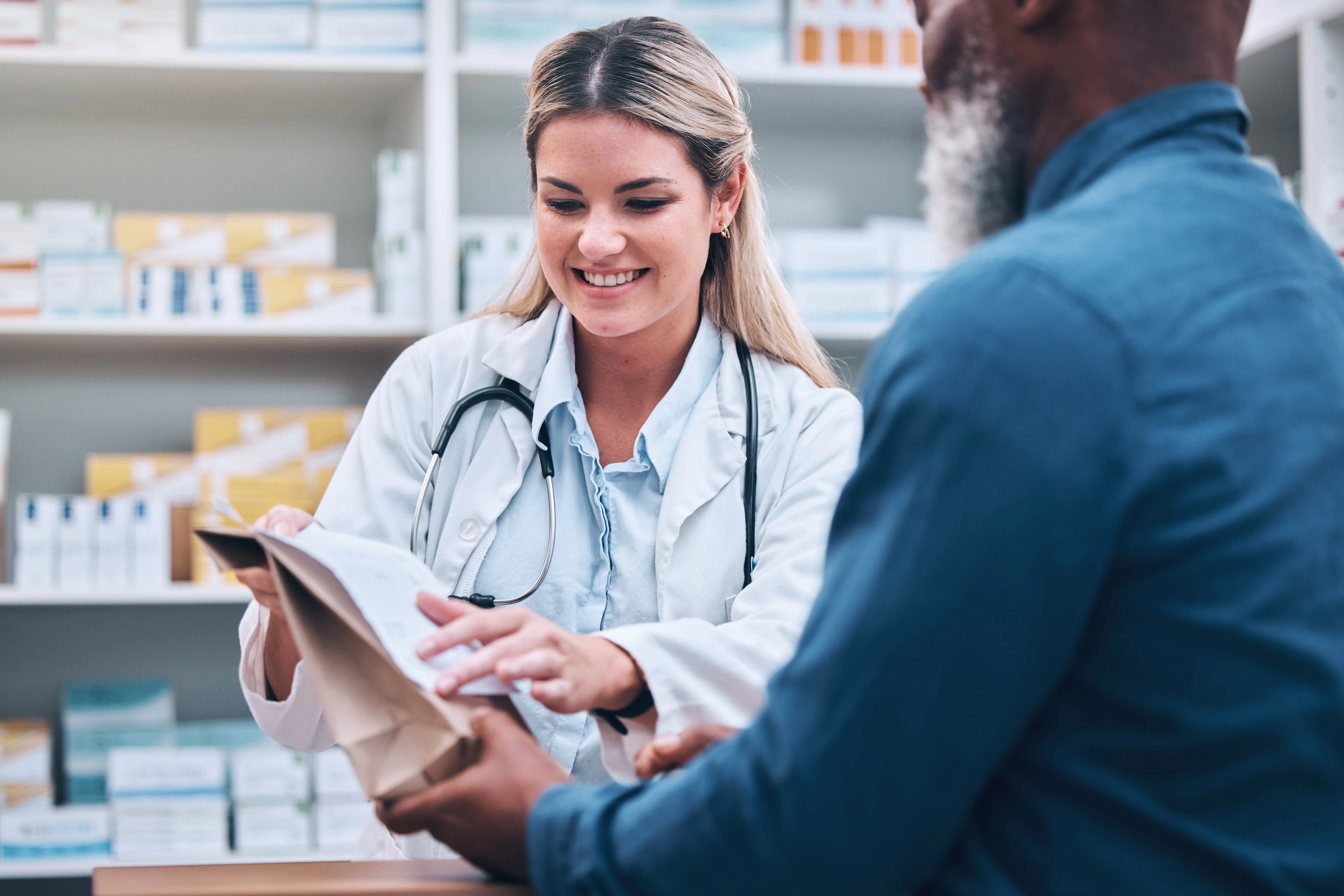 Apothekerin berät einen Kunden zu verschreibungspflichtigen Medikamenten.